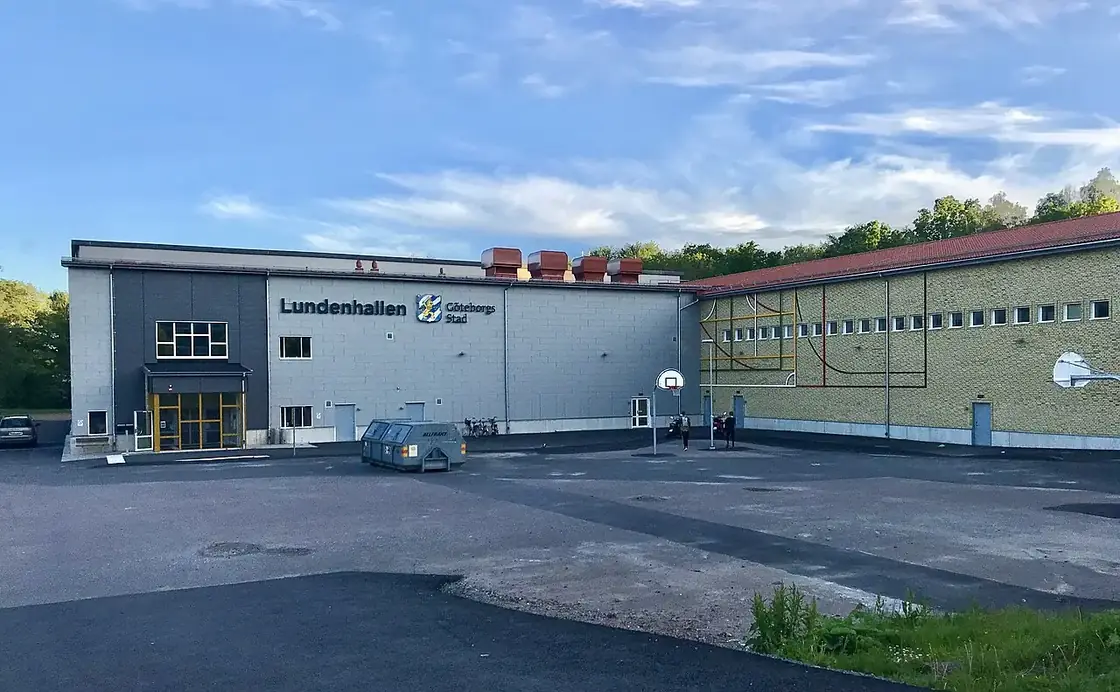 Lundenhallens fasad med skylt och asfalterad parkering framför entrén